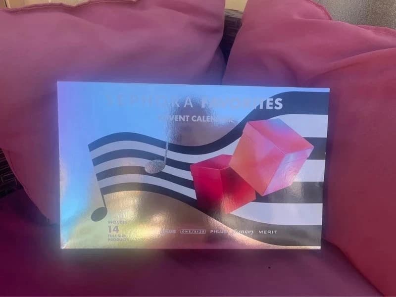 Calendrier Sephora Favorites posé sur des coussins roses